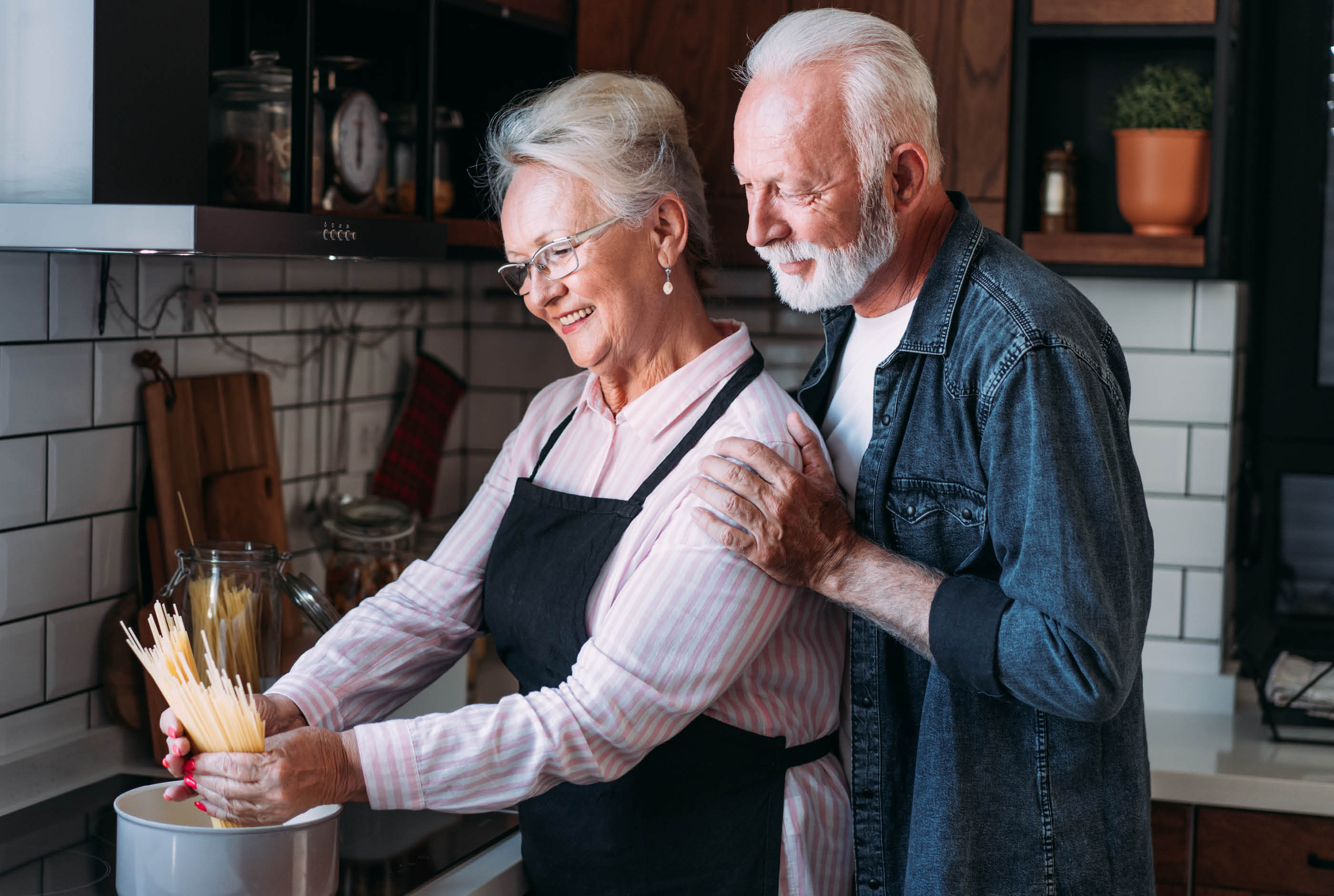 Frau und Mann kochen Spaghetti in der Küche